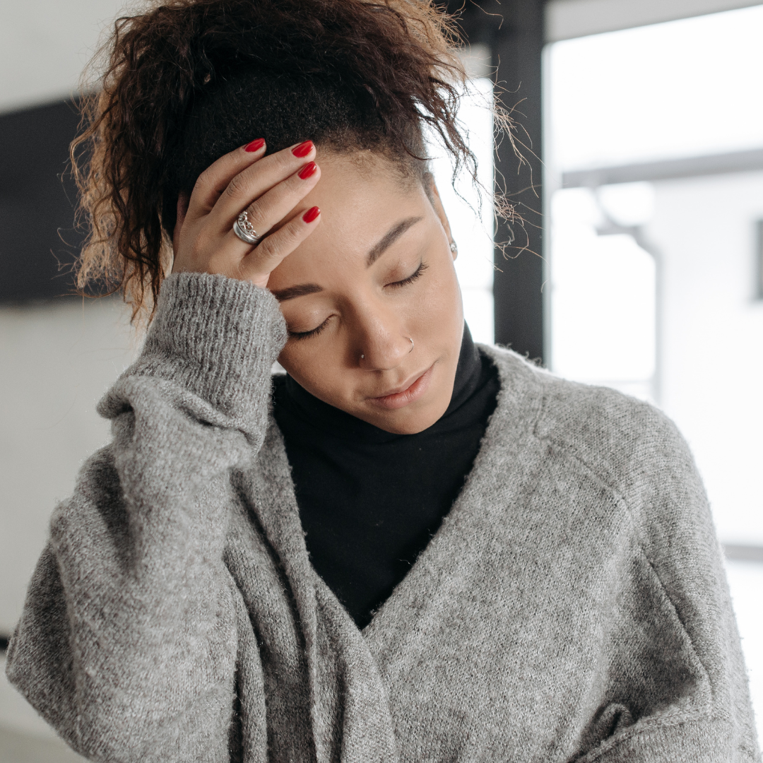 woman holding her head in her hand